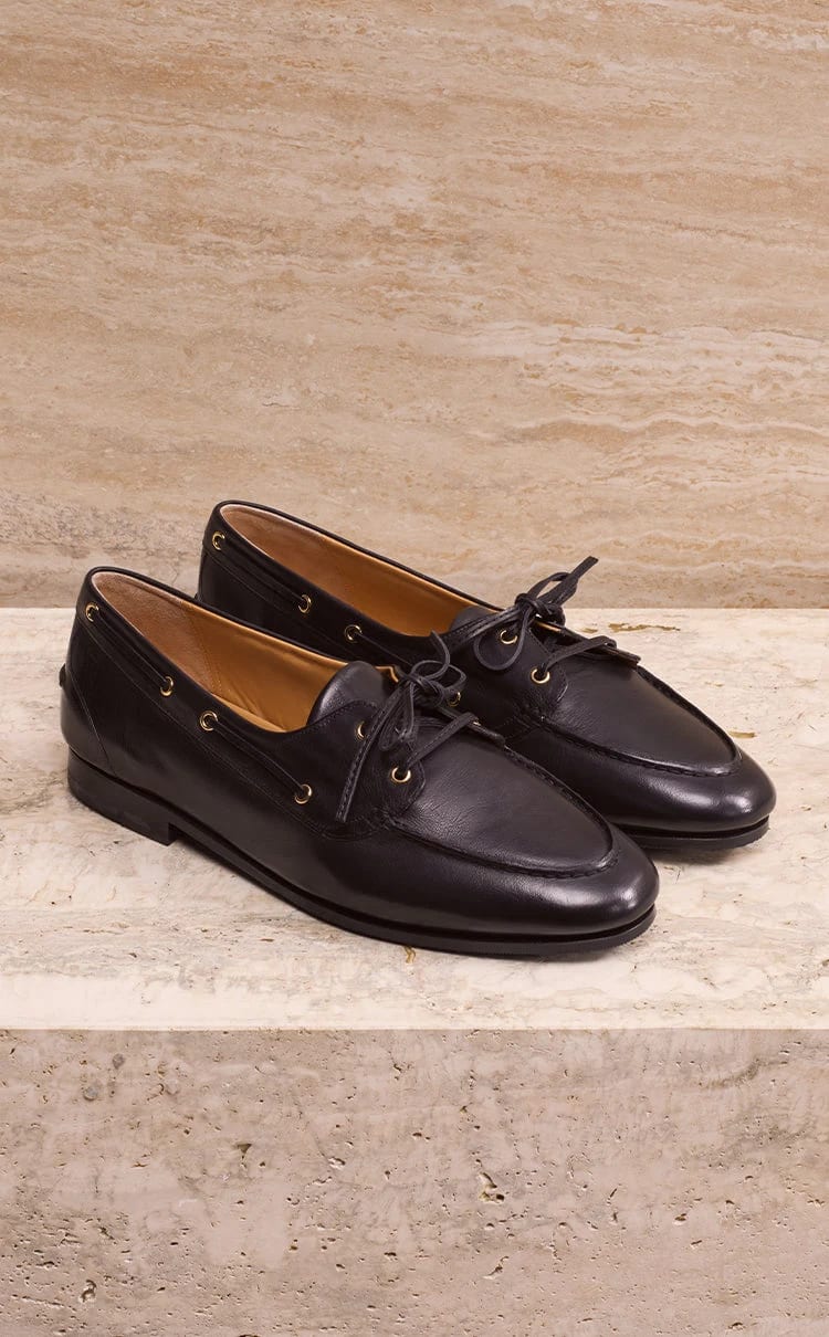Bally black leather shoes displayed on pale stone
